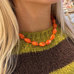 Le collier en or est orange.